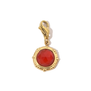 Detail of a red faceted gemstone pendant with gold lobster clasp and stainless steel frame