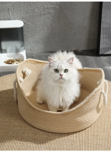 Dettaglio della trama in corda di cotone su una cuccia rotonda beige per gatti con manici