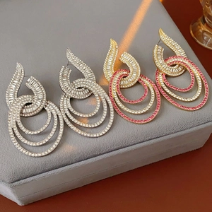 Detail of luxury geometric hoop earrings with crystals in gold and silver finishes