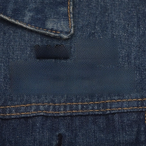 Detail of 5 black enamel pins with funny sarcasm quotes on a blue denim jacket