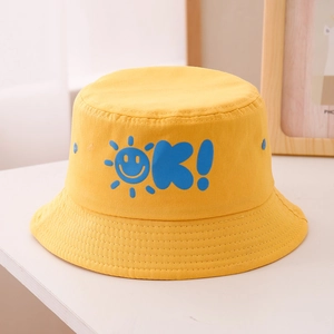 Dettaglio del cappello da sole giallo in cotone per bambini con sole sorridente e ricamo