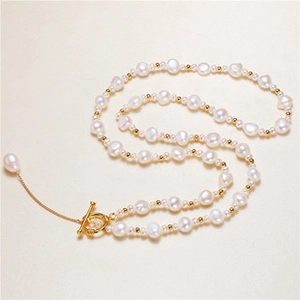 Flat lay of elegant baroque pearl necklace with gold beads and a vintage OT clasp