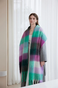 Close-up of thick plaid scarf with purple and green tones and fringe detailing