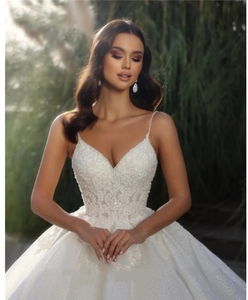 Detail of a bridal gown bodice featuring fine straps and shimmering beadwork embroidery