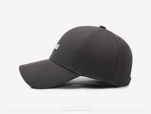 Détail de la casquette de baseball gris foncé avec broderie de lettre 3D sur le côté