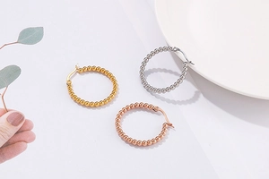 Detailed view of beaded hoop earrings in gold, silver and rose gold finishes