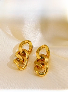 Close-up of 18K gold-plated stainless steel triple link chain earrings on silk