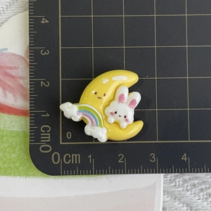 Macro shot of resin rabbit on moon accessory with rainbow detail on measurement ruler