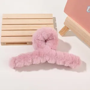 Detailed view of large pink plush hair claw clip with soft faux fur texture for winter