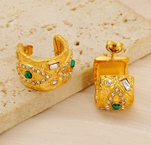 Détail macro de boucles d'oreilles vintage en or avec malachite verte et strass brillants