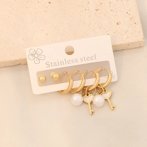 Gros plan d'un ensemble de boucles d'oreilles en acier avec perles et pendentifs cœur