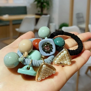 Detail of Korean style hair tie featuring pearls and pastel resin beads on wrist