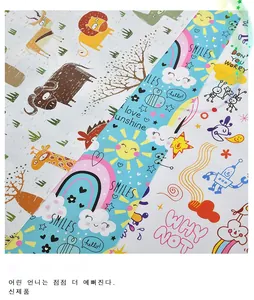 Macro view of three cartoon wrapping paper designs with animal, rainbow and robot patterns