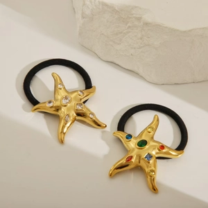 Starfish hair ties with 18k gold plating and colorful rhinestones on a white rock