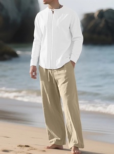 Détail de chemise en lin blanche à col officier et pantalon de plage couleur kaki