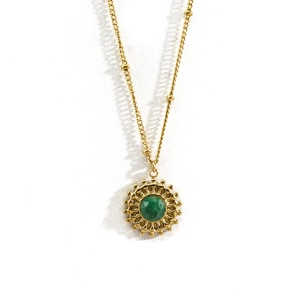 Détail du collier doré avec pendentif en pierre naturelle verte et bordure soleil