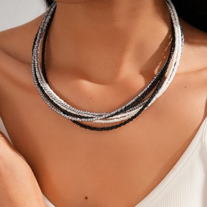 Close-up of layered bohemian beaded necklace with black, white and silver beads