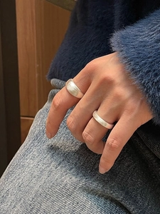 Detailed view of wide frosted sterling silver ring with brushed matte texture on finger