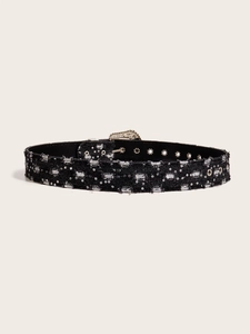 Detail of black denim belt featuring silver sequins, metal eyelets and a polished buckle