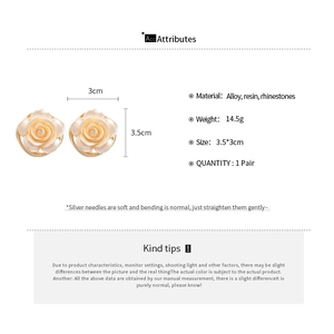 Détail de boucles d'oreilles rose avec pétales en résine blanche et petits strass brillants