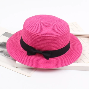 Flacher Strohhut in Fuchsia mit schwarzer Bandschleife als Sonnenschutz für den Sommer