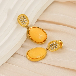 Detail of vintage gold oval earrings with yellow resin stone and sparkling white crystals