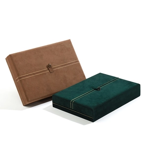 Brown and dark green velvet jewelry boxes with elegant gold snap and decorative line detail