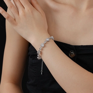Detail eines Herz-Zirkonia-Armbands mit Silberkette am Handgelenk des Models
