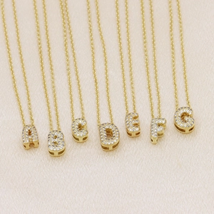 Detail of gold bubble letter pendants A-G with full cubic zirconia on fine chains