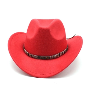 Detail of red wool felt cowboy hat with colorful woven band and gear charms