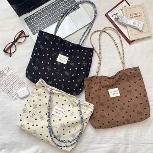 Three corduroy tote bags in black, beige, and brown with cute bow and heart pattern prints