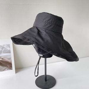 Detail of wide brim black sun hat showing textured quick-dry fabric and windproof cord