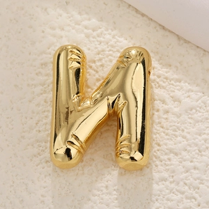 Detailed close-up of a 3D bubble letter N pendant in gold-plated high-polish finish