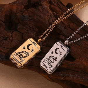 Macro detail of 18K gold and silver Tarot Strength pendant on natural wood background