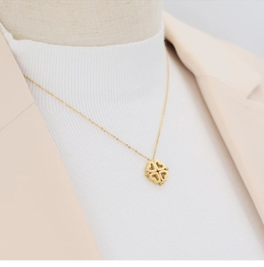 Gros plan du collier trèfle plaqué or 18 carats avec cœurs pliables sur un modèle