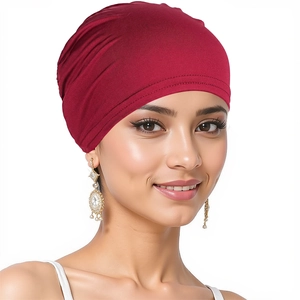 Close-up of red stretch turban hat worn by a model showing soft fabric texture and fit