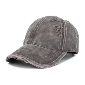 Close-up of distressed denim baseball cap showing vintage washed texture and ripped detail