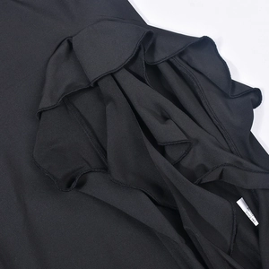 Close-up of ruffled hem and fine stitching on a black sexy cut-out mini dress