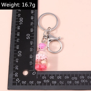 Detailed view of 16.7g fruit wishing bottle keychain with pink liquid and tiny shell fillers