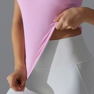 Détail du débardeur de sport côtelé rose avec un legging de yoga blanc à taille haute