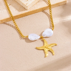 Gold stainless steel starfish necklace featuring baroque pearls on beige stone