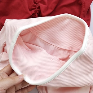 Detail of high-waist ribbed yoga shorts showing pink and dark red seamless knit fabric