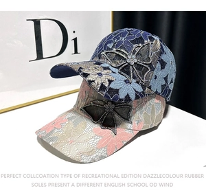 Detailed view of women's floral lace baseball caps with sparkling rhinestone butterfly