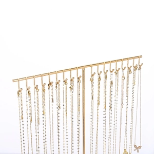 Golden T-bar iron jewelry stand organizer displaying butterfly pendant necklaces on white background