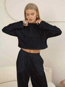Détail du tissu noir ajouré de l'ensemble loungewear avec haut à manches longues et pantalon