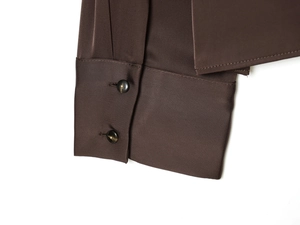 Close-up of poplin shirt cuff with marble-textured buttons and premium stitching