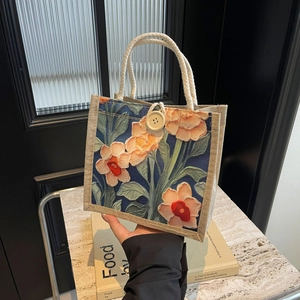 Close-up of floral jute tote bag featuring 3D embossed pattern and wooden button closure