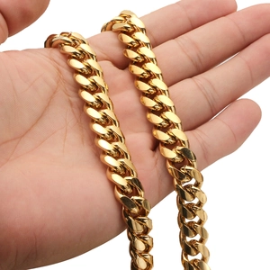Close-up of a hand holding a thick gold Cuban link chain with detailed metal texture
