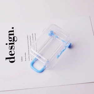 Mini transparent luggage-shaped jewelry box with light blue wheels and handles