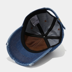 Detailed view of blue vintage denim baseball cap showing 100% cotton material and stitching